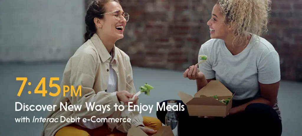 Two women sitting on the floor enjoy a meal purchased with INTERAC debit.