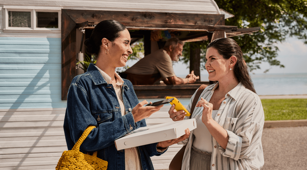 A woman, a man and a boy, all smiling; the adults are holding smartphones.