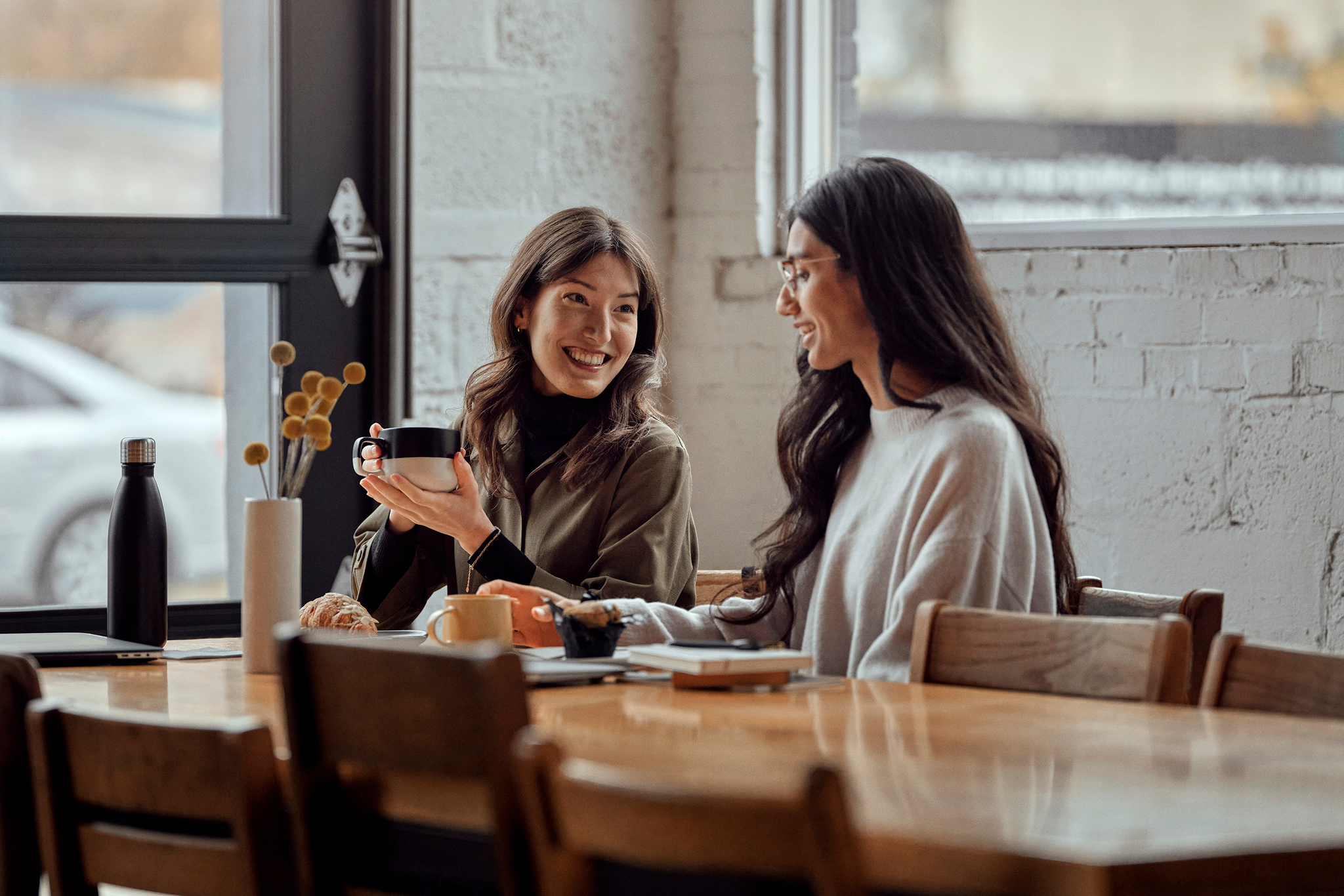 Deux femmes parlent de la sécurité des transactions numériques dans un café.