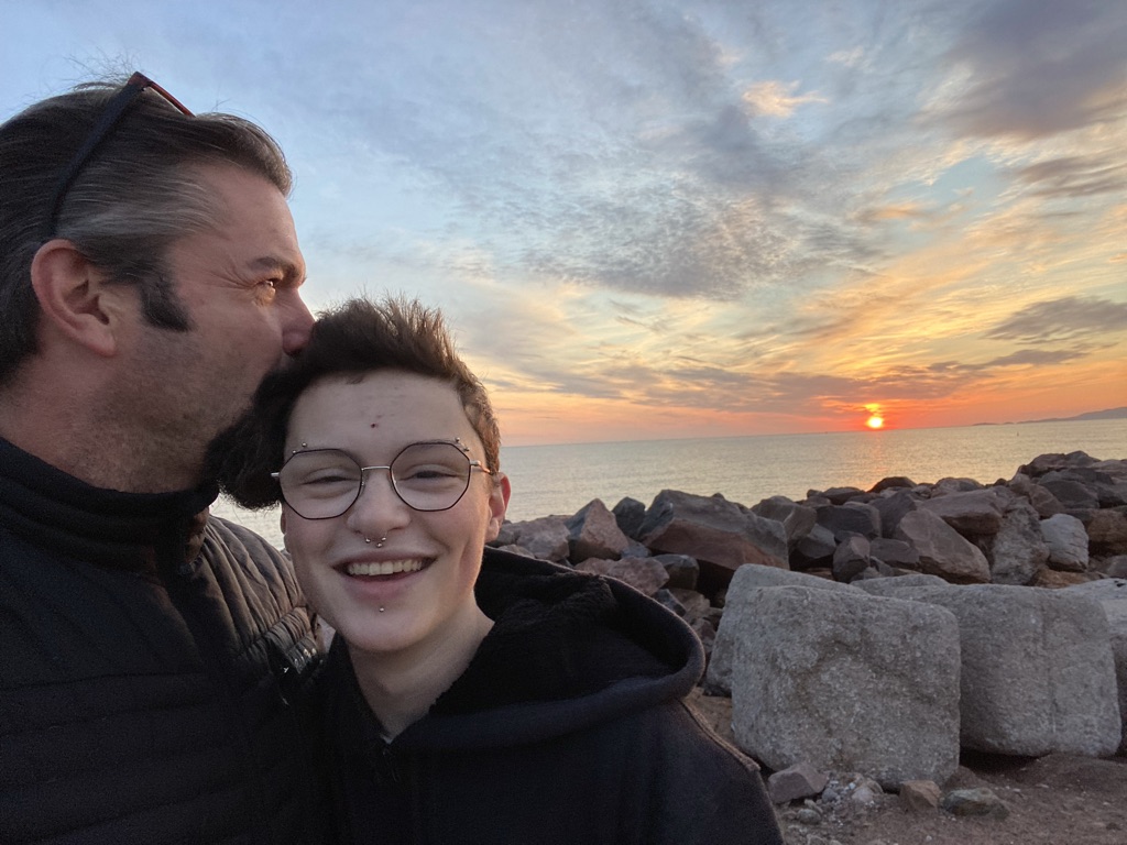 Grateful for diversity & inclusion in the workplace, Eric kisses his child’s head as the sun sets.