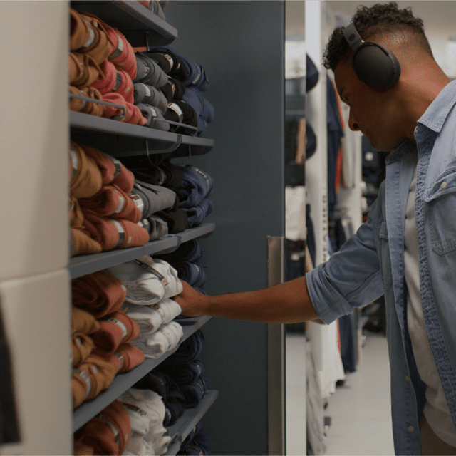 Photo of person wearing headphones and listening to music while shopping at a clothing store