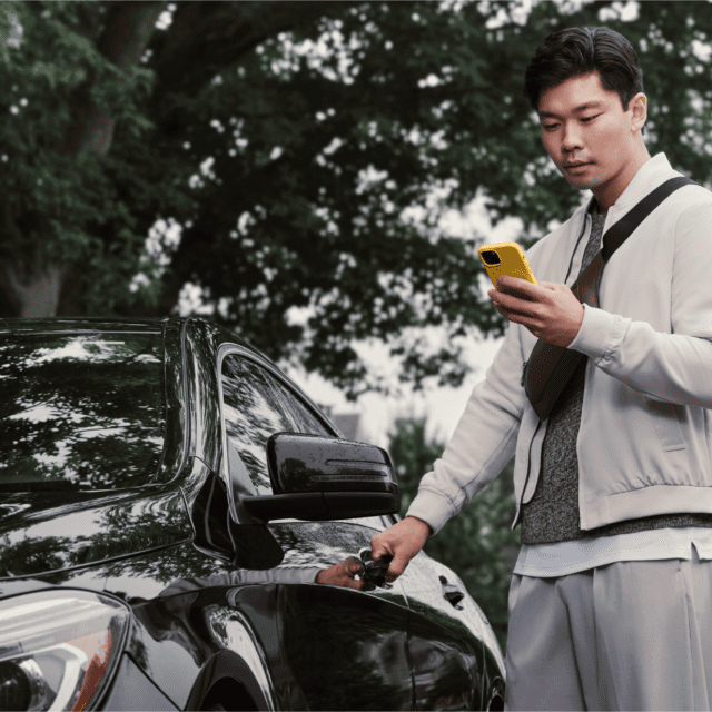 Man beside his car looking at his phone