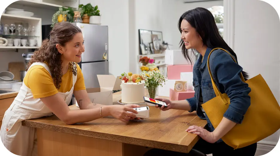 A woman uses her phone to pay for a purchase using Interac Debit